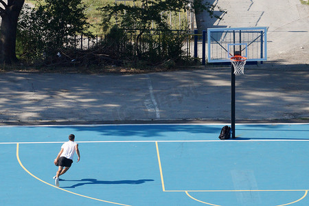 年轻人在室外篮球场上带球训练