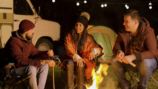 秋天寒冷的夜晚，一群亲密的朋友在篝火旁一起放松