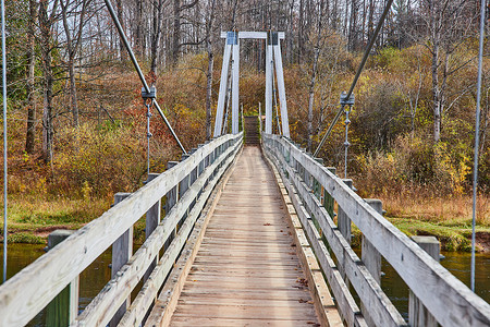 森林吊桥摄影照片_俯瞰密歇根公园河上的大型吊桥