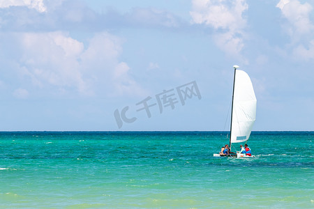 大海种族摄影照片_明亮阳光下白色帆船的航海背景，蓝色海水，有文字空间
