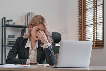 电脑工作女摄影照片_疲惫的女商人因长时间坐在办公桌前而昏昏欲睡、无聊，患有办公室综合症