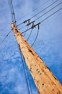 抬头看着浅棕色的电线杆，上面有蓝天和数字 5 9 6
