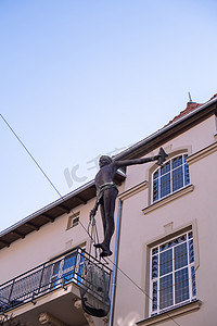波兰索波特 — 2022 年 5 月，男孩渔夫在两栋建筑外部之间的绳子上保持平衡的雕塑。
