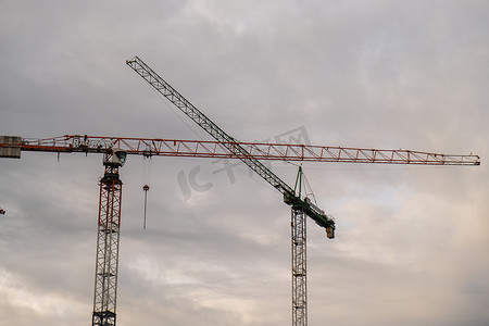 波兰格但斯克 2022 年 5 月，城市上空日出时建筑起重机和未完工住宅楼的轮廓。