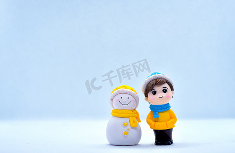 旅游和旅行概念：微型小男孩和雪人站在孤立的背景中