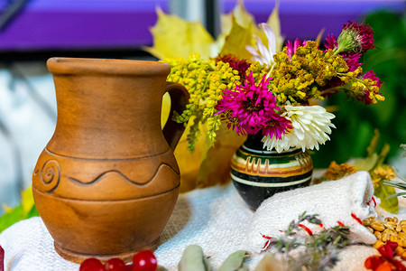 牛奶摄影照片_乌克兰粘土牛奶壶和花瓶里的花