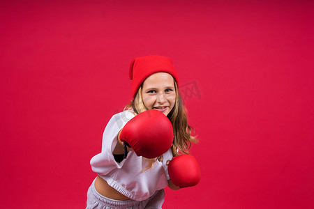 小女孩戴着红色拳击手套，工作室拍摄，运动概念