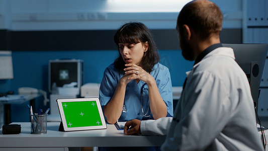 Nure 在用绿屏分析平板电脑时与医生讨论医疗报告