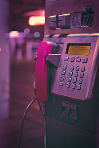 德国杜伊斯堡一个带粉色手机的公共电话亭的垂直特写镜头