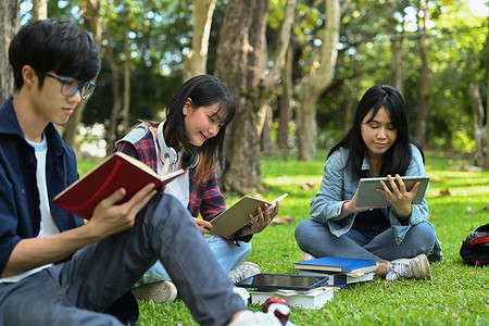 年轻的大学生坐在校园里读书，准备考试。