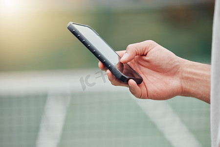 未知的混血网球运动员在场上比赛休息时使用手机的特写。