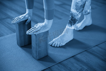 女性用手木块练习瑜伽伸展，锻炼脊柱和肩膀的灵活性