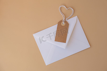 白色信封，配有米色纸币和心形绳索，中性米色背景。