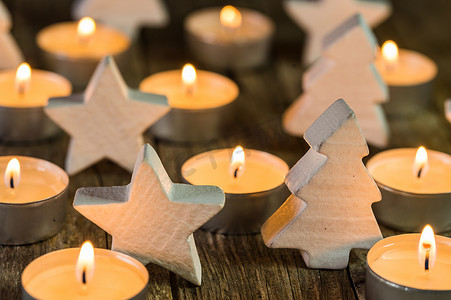 降临蜡烛火焰与白色木制圣诞装饰品