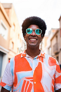大头钉书签摄影照片_年轻快乐、微笑的黑人戴着太阳镜在户外的垂直肖像。