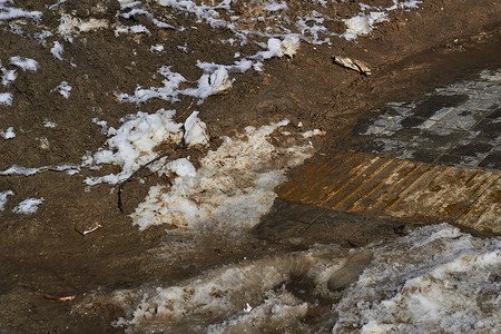 淤泥摄影照片_融化的水坑淤泥越野雪和泥土。