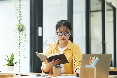 严肃的年轻亚洲学生正在读书准备考试。