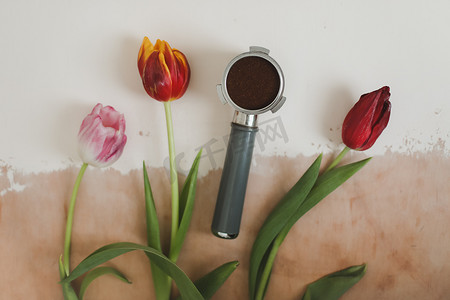 装饰平躺组合物，配有咖啡豆和鲜花顶视图、春天、咖啡馆概念、饮料和制作咖啡概念。