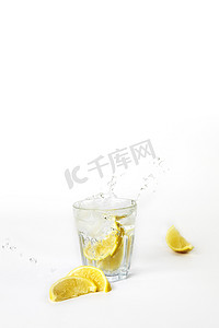 柠檬水溅摄影照片_一杯柠檬水，白色背景上溅水，有复制空间