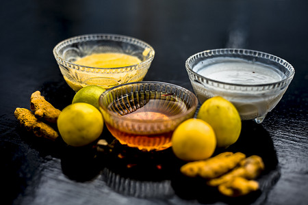 将柠檬汁、蜂蜜、凝乳和一些生姜黄混合在玻璃碗中，与木质表面上的所有原料一起混合，以治疗易长粉刺的皮肤和瑕疵。