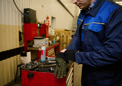 汽车工程师、机械师、技术员在修理店测试汽车之前戴上防护工作手套的特写镜头。