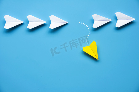 黄纸飞机折纸将其他白色飞机留在蓝色背景上，并为文本或想法提供可定制的空间。