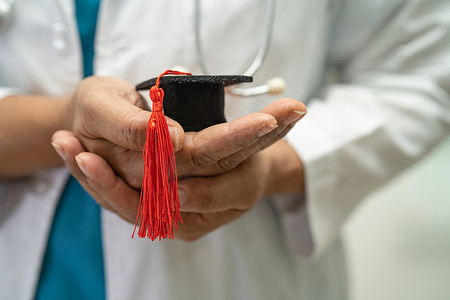 论文毕业摄影照片_亚洲医生在医院病房学习毕业间隙帽子，聪明聪明的天才教育医学理念。