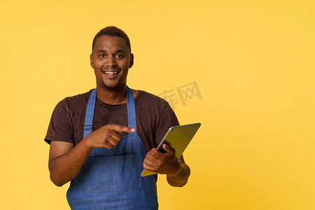 值得信赖摄影照片_年轻、才华横溢的非洲裔美国厨师在他值得信赖的平板电脑上寻找完美的食谱。