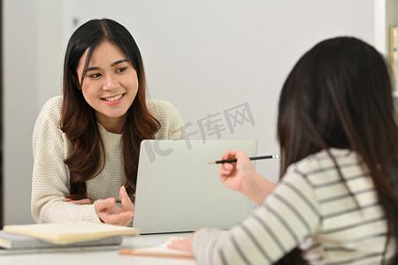 补习学习摄影照片_微笑的年轻母亲和小女儿做作业，在家学习。