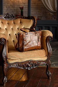黄色丝绒复古扶手椅上棕色皮包的特写照片。
