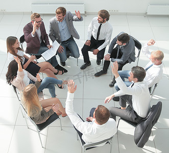 一群年轻的员工在会议室里坐成一圈。