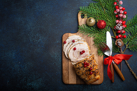 圣诞烤火腿切片，配上红色浆果和节日装饰