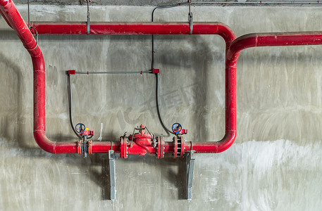混凝土墙上有闸压阀的红水或燃气管道。
