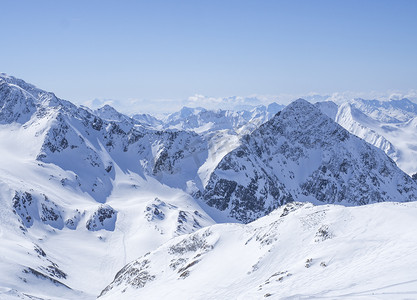 在春天阳光明媚的日子，从 Stubai Gletscher 滑雪区的 Schaufelspitze 山顶欣赏冬季景观，山峰被雪覆盖。