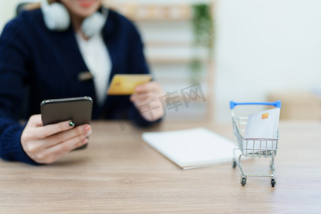 办事指南摄影照片_网上购物和互联网支付，亚洲男性正在使用信用卡和手机在数字世界中网上购物或办事。