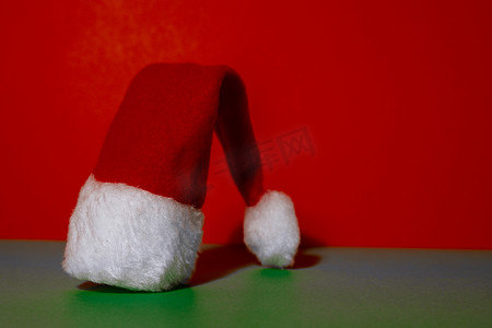 等距绿色红色背景上的圣诞老人帽子。