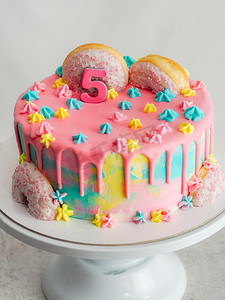 白色背景上的粉红色五周年生日磨砂糖霜滴蛋糕
