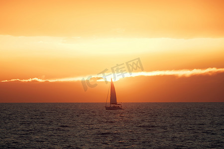 美丽的日落在海上与帆船