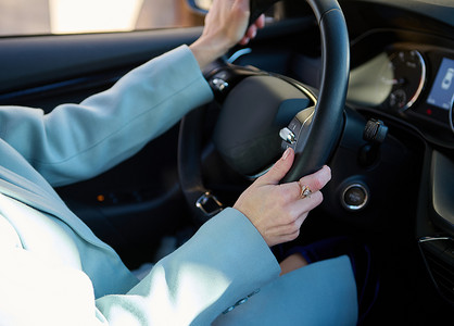 现代汽车中女司机的特写手放在方向盘上。