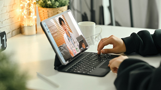 妇女在数字平板电脑上与医生在线咨询的裁剪镜头。