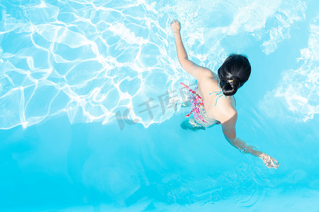 亚洲比基尼摄影照片_亚洲女性在游泳池中享受的顶级景观