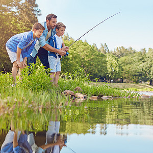 钓鱼内容摄影照片_教他的孩子们如何钓鱼。