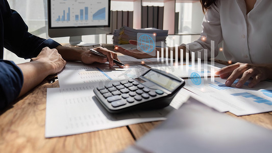 女性和男性会计师使用计算器通过财务和分析研究、收入、税收和业务增长的数据网络连接来计算公司财务业绩