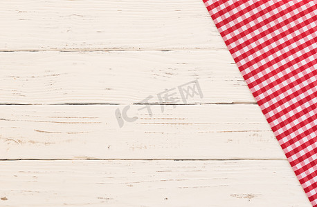 白色木制餐桌背景上的红色方格桌布