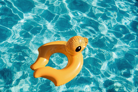 泳池的顶视图摄影照片_白天在泳池里游泳的黄鸭玩具的顶视图