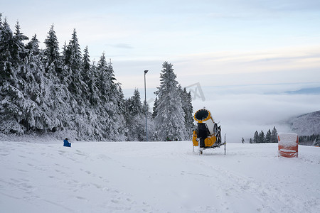 德国罗恩黑塞州 Wasserkuppe 滑雪胜地的黄色人造雪炮，2022 年 12 月新降雪后的雪山上