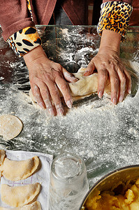 乌克兰民族美食中，一位家庭主妇用手揉面团，用土豆制作瓦雷尼基。