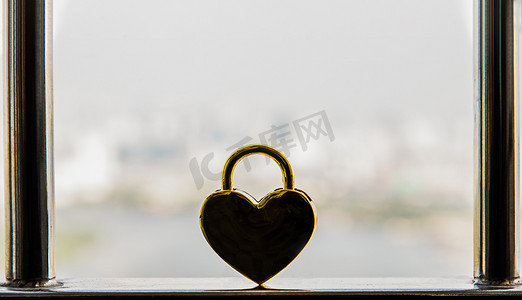 不锈钢阳台栏杆上的金色心形爱情挂锁。
