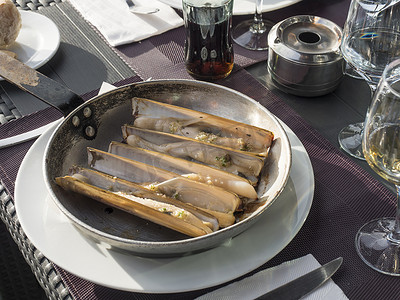 拉帕尔马海鲜餐厅餐桌上的烹饪锅上特写着大西洋折刀剃须蛤