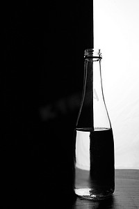 一瓶黑色和白色背景上的水。